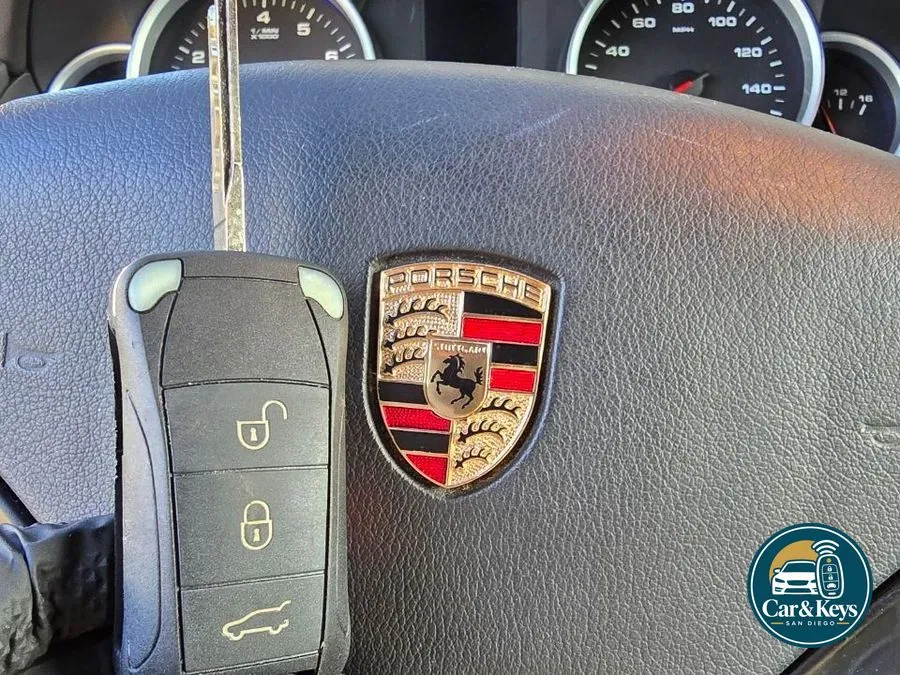 A Porsche key in hand at the car